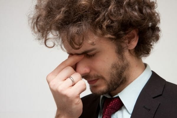 ストレスが原因で偏頭痛・慢性頭痛に悩む男性の画像