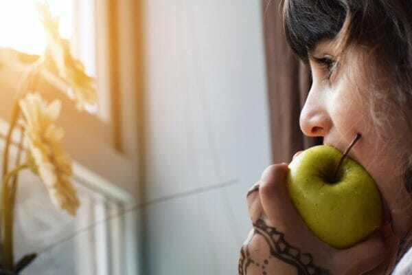 リンゴ酢ダイエットをしようとりんごにかじりついている女性のイメージ
